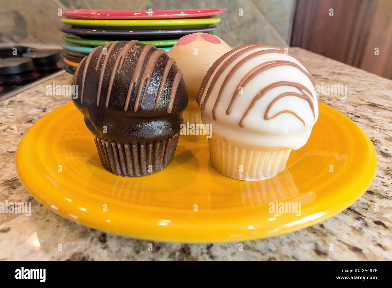 Süßes Dessert Cupcakes auf gelbe Platte sitzen auf Granit Küchenarbeitsplatte Stockfoto