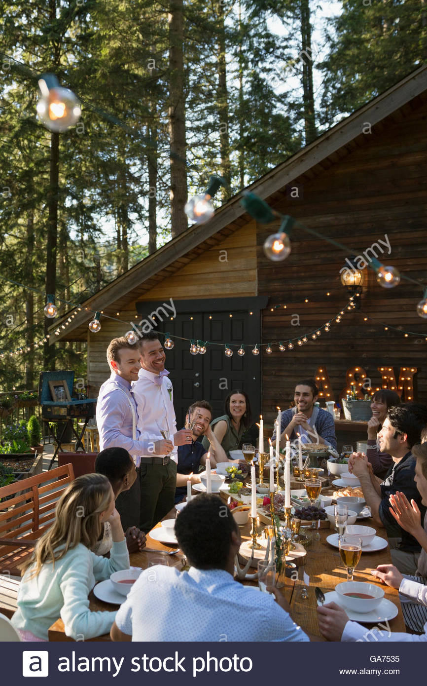 Homosexuelles Paar Bewältigung Freunde am langen Tisch auf Hochzeit Stockfoto