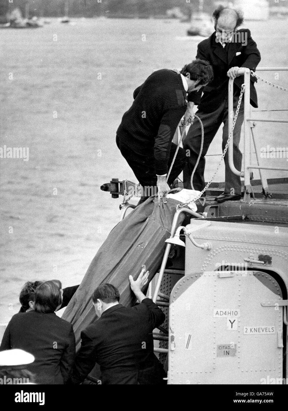 AJAXNETPHOTO. 16. AUGUST 1979. DEVONPORT, PLYMOUTH, ENGLAND. -FASTNET RACE TRAGÖDIE - DER KÖRPER EINES BESATZUNGSMITGLIEDS STARB AN BORD DER YACHT TROPHY AUS DER NIEDERLÄNDISCHEN FREGATTE OVERIJESSEL AN LAND GEBRACHT.  FOTO: JONATHAN EASTLAND/AJAX REF: 1979 2 Stockfoto