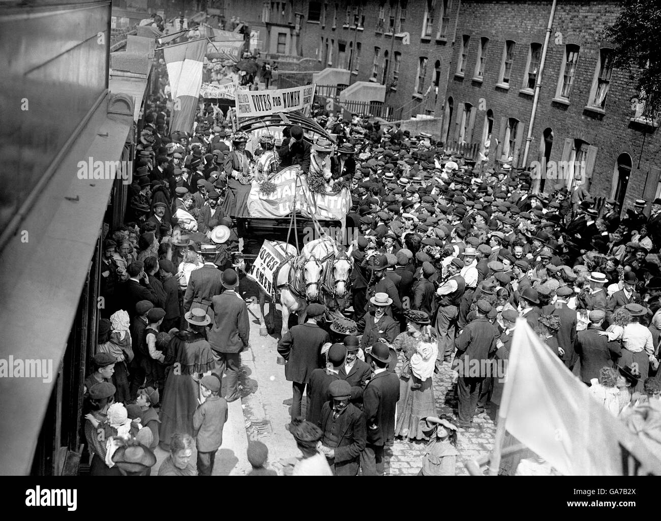 Menschenmassen beobachten eine Suffragette Parade. L-R: Frau Pankhurst, Miss Clark, ihre Schwester, der Fahrer, Charlotte Marsh und Jessie Kelly. Stockfoto