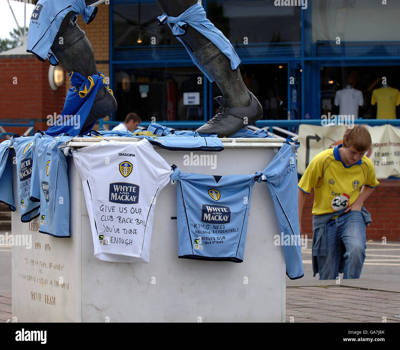 Anhänger von Leeds United platzieren Mannschaftstrikots mit Botschaften um die Statue von Billy Bremner in der Elland Road, Leeds. Stockfoto