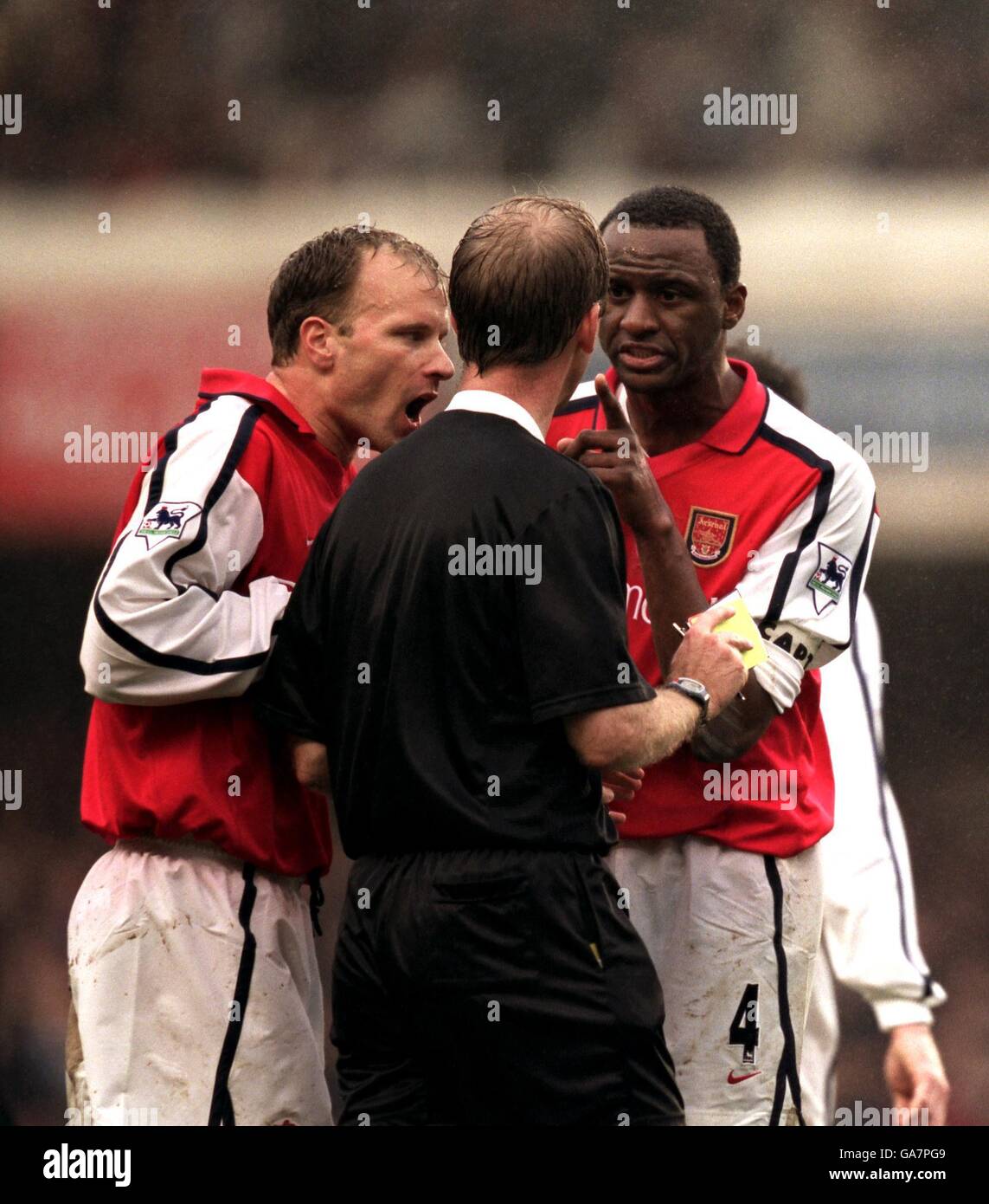 Dennis Bergkamp und Patrick Vieira von Arsenal haben Worte mit Schiedsrichter Mike Riley nach dem Abschicken Stockfoto