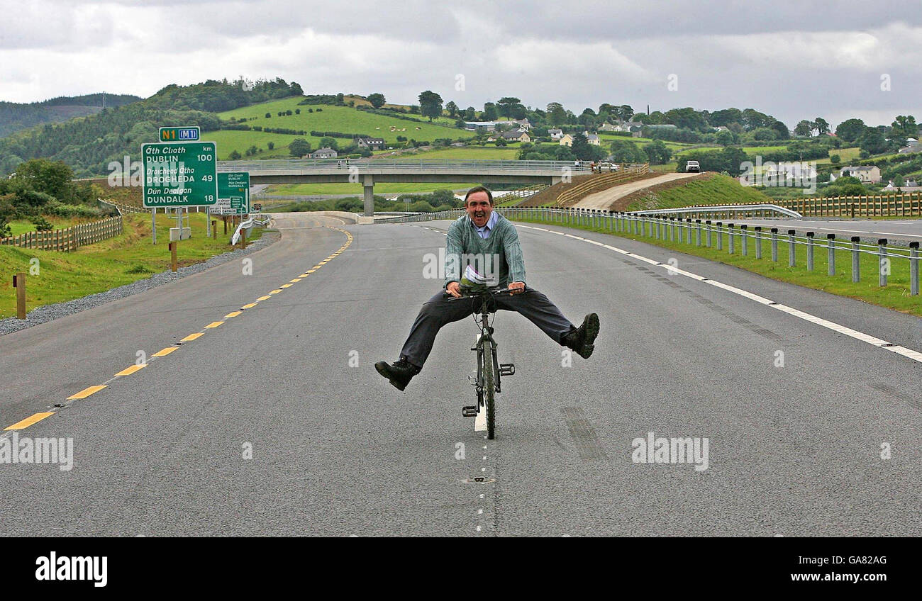 Der Einheimische Sean Donnelley fährt mit seinem Fahrrad entlang der neuen A1N1 Newry Dundalk Link Road und ist damit der erste, der die Straße benutzt. Stockfoto