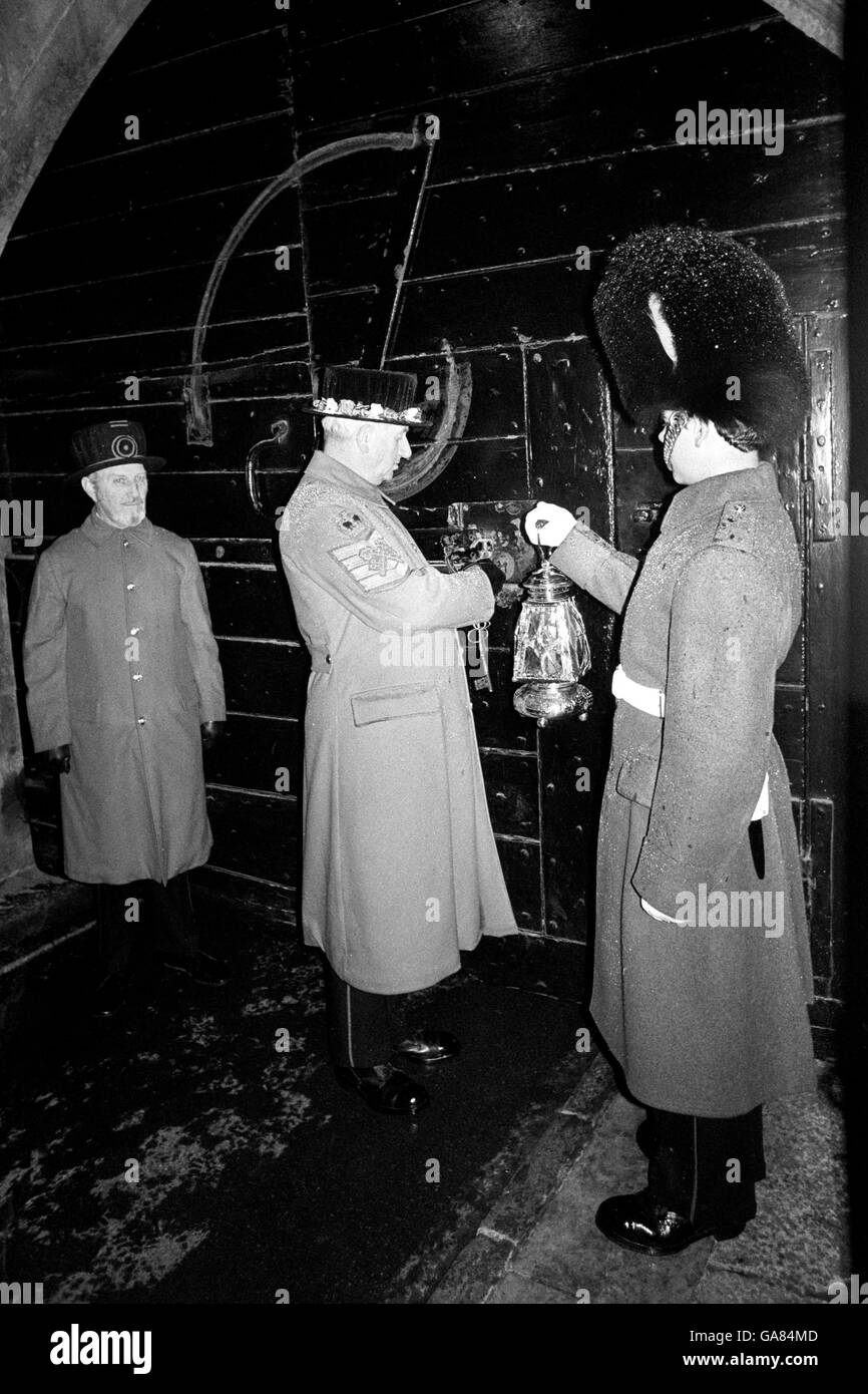 Der Chief Yeoman Warder, der die großen Eichentore des Mittelturms während einer besonderen Inszenierung der Zeremonie der Schlüssel am Tower of London einsperrte. Stockfoto