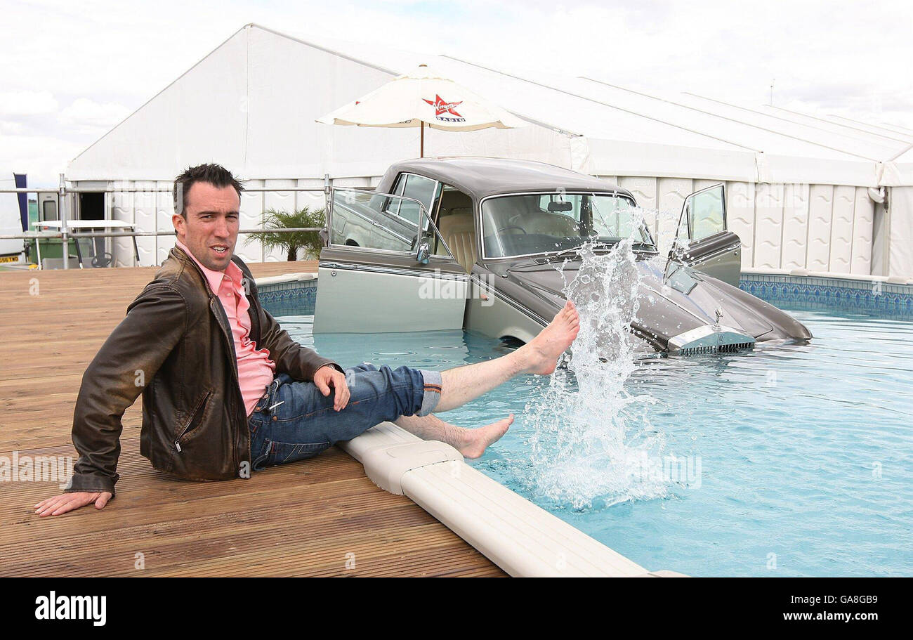 Christian O'Connell von Virgin Radio ist mit dem Rolls Royce von DJ Suggs zu sehen, der in einem Schwimmbad hinterlegt wurde, nachdem dieser eine Wette auf Luft verloren hatte, Chelmsford, Essex. Stockfoto