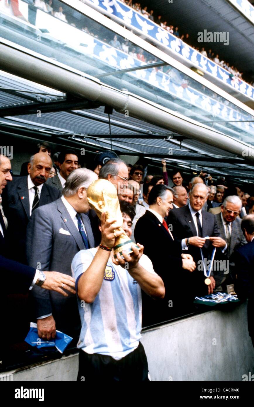 Argentiniens Kapitän Diego Maradona hebt die WM als FIFA an Präsident Joao Havelange (zweite R) Bereitet sich darauf vor, die Siegermedaillen auszuhändigen Stockfoto