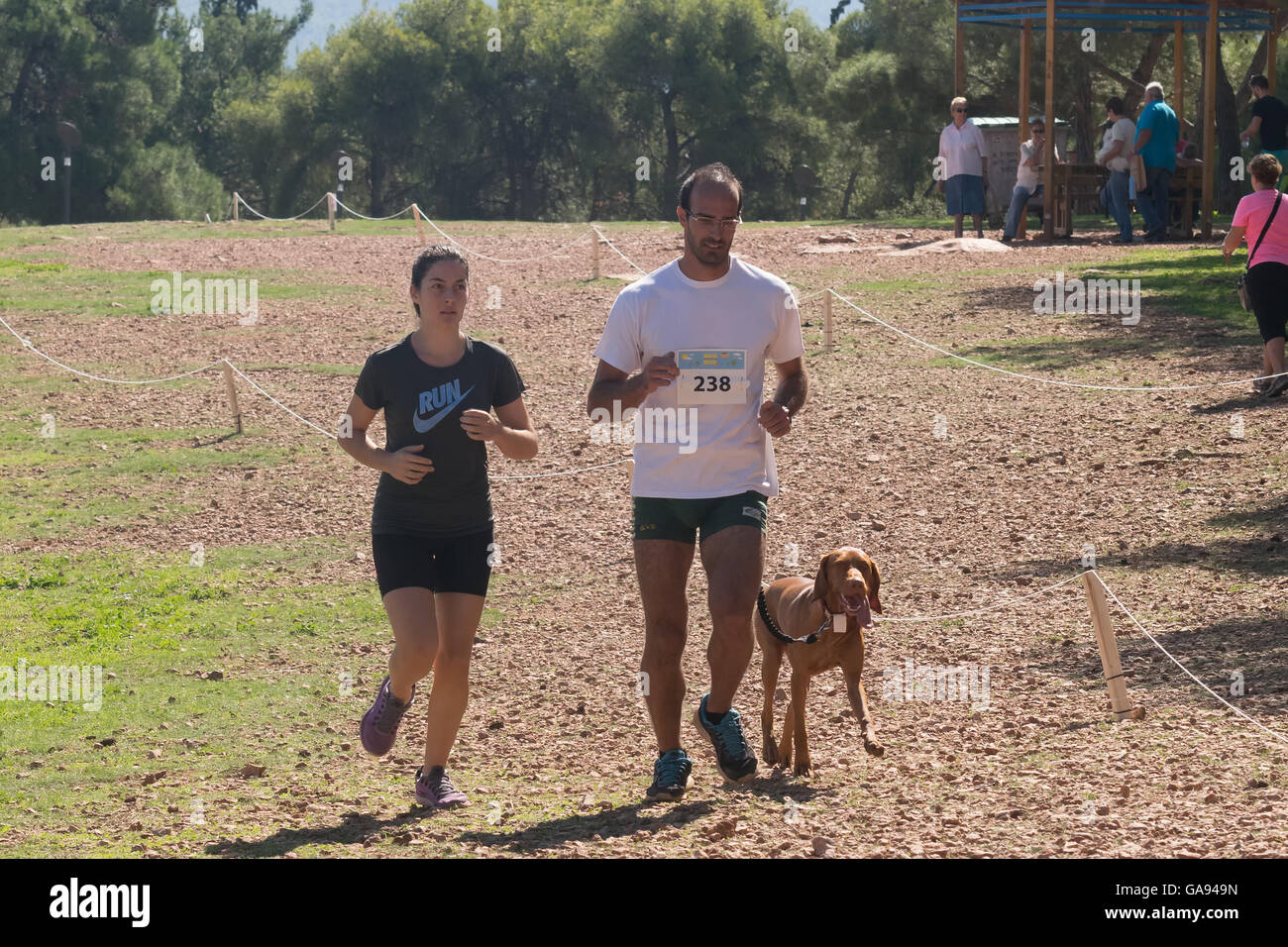 Athen, Griechenland 4. Oktober 2015. Mann und Tochter in der Familie Wettbewerb läuft laufen mit Ihrem Hund in Griechenland. Stockfoto