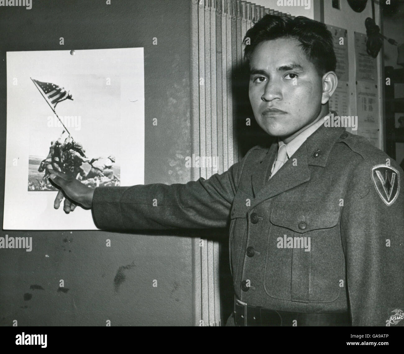 Marine Private First Class Ira Hayes zeigt das Teil spielte er in der Ansammlung von Stars And Stripes auf Mount Suribachi, Iwo Jima mit dem Hinweis auf sein Bild auf dem historischen Foto des Ereignisses. 1945. Stockfoto