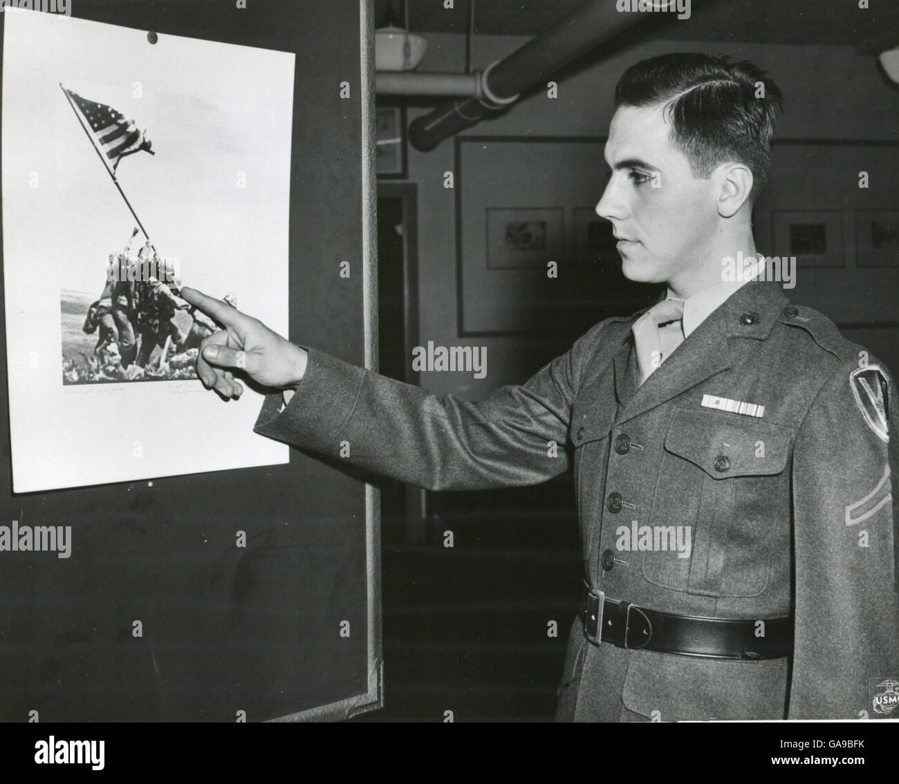 Marine Private First Class Rene Gagnon verweist auf die Figur von sich selbst auf den Fotos der Marines Anhebung Old Glory auf Iwo Jima Berg Suribachi. Das Bild wird für das neue 7. Kriegsanleihe Poster verwendet werden. Stockfoto