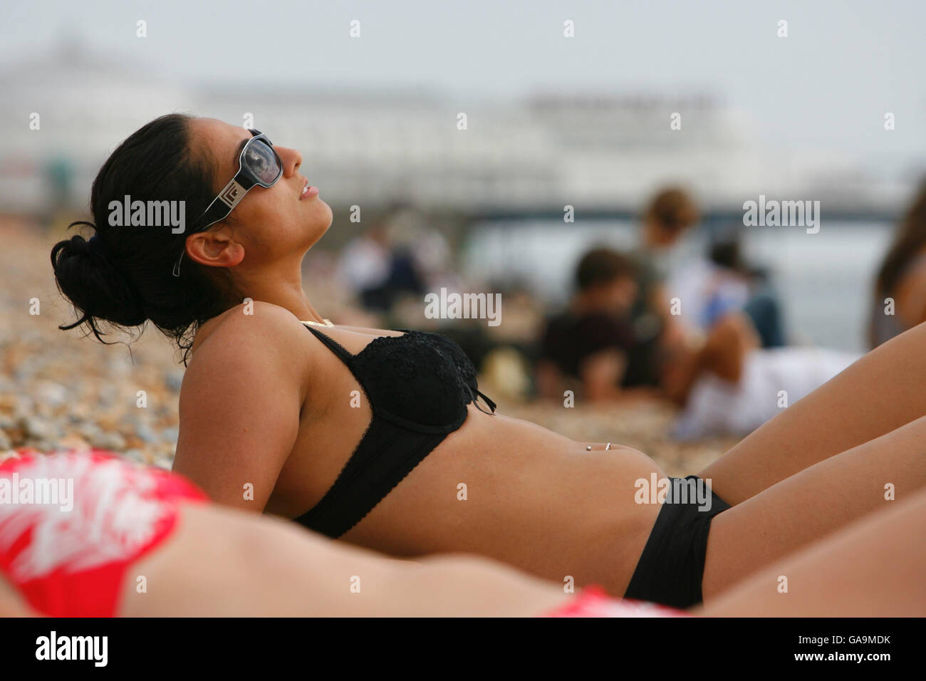 Sonnenanbeter genießen die letzte Sommersonne am Brighton Beach, Sussex. Stockfoto