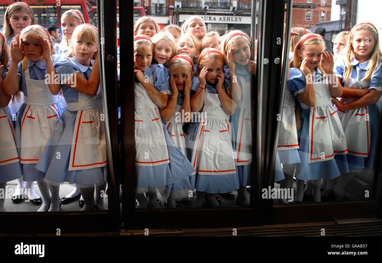 Eine Gruppe von Mädchen, die als Alice im Wunderland gekleidet sind, werfen einen Blick auf den neuen Wonder Room of Jewelry, Uhren und Luxusgeschenke im Kaufhaus Selfridges in London. Stockfoto