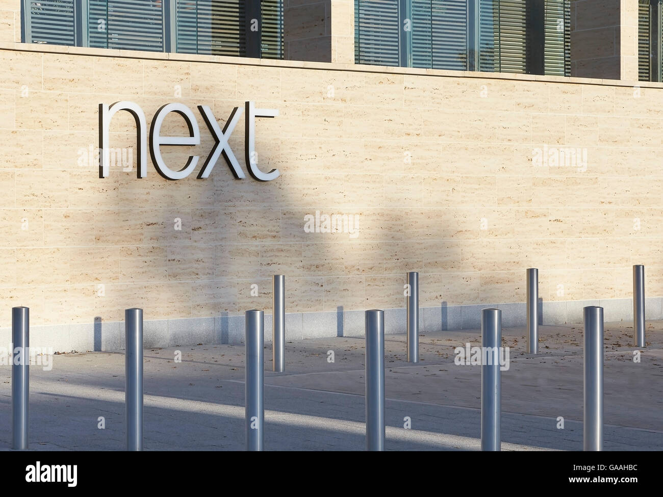 Detail der Fassade mit Firmenlogo. Next - Haus und Garten Shops, Southampton, Vereinigtes Königreich. Architekt: Stanton Williams, 2014. Stockfoto