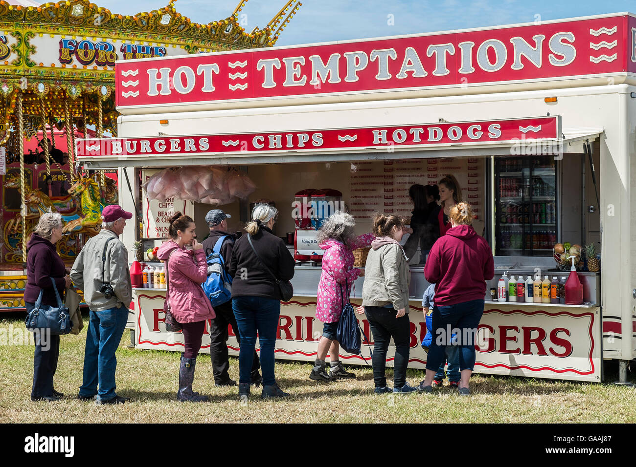 Menschen, die Warteschlangen an einem Fast-Food stall auf einer Messe. Stockfoto