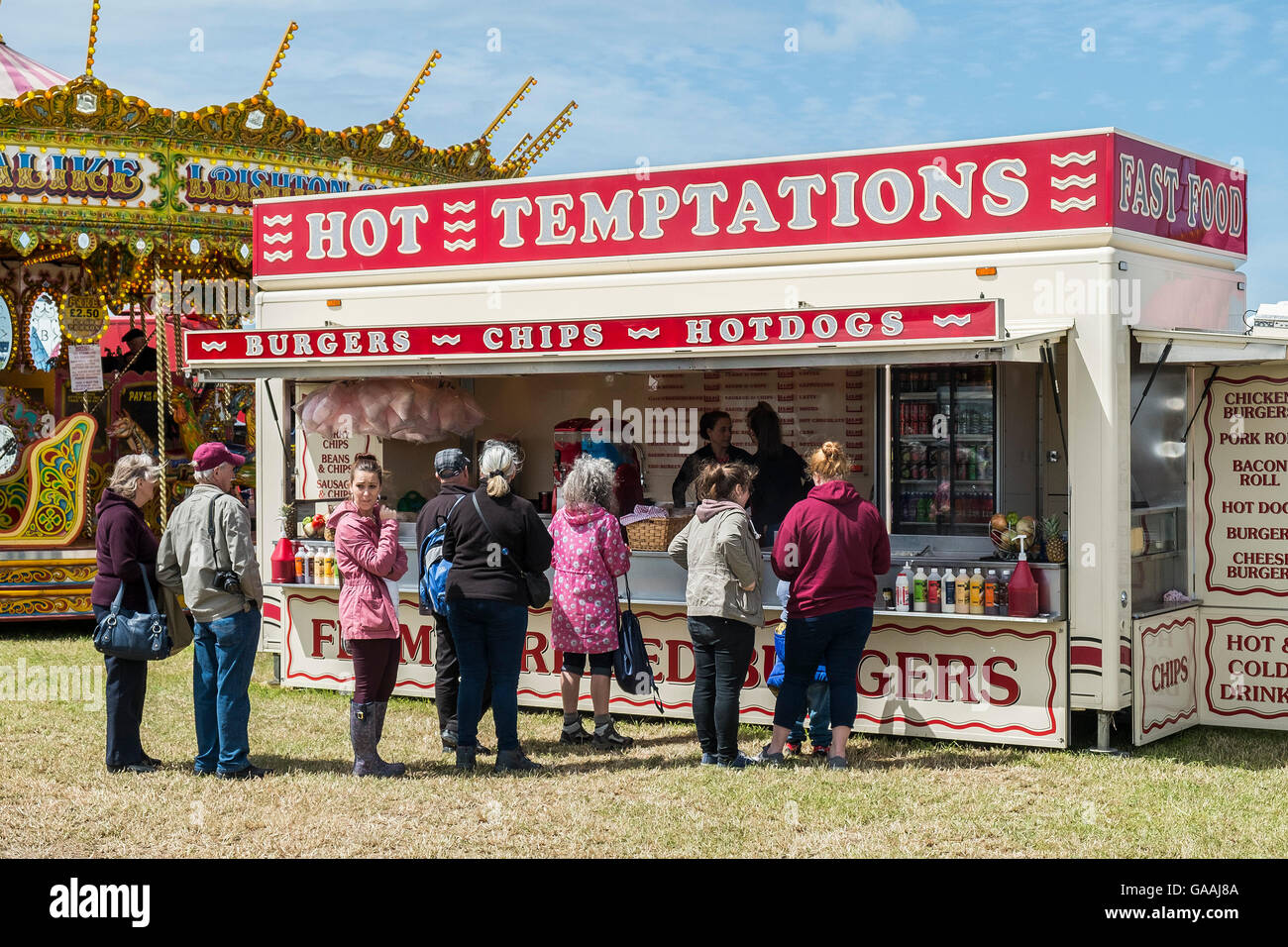 Menschen, die Warteschlangen an einem Fast-Food stall auf einer Messe. Stockfoto