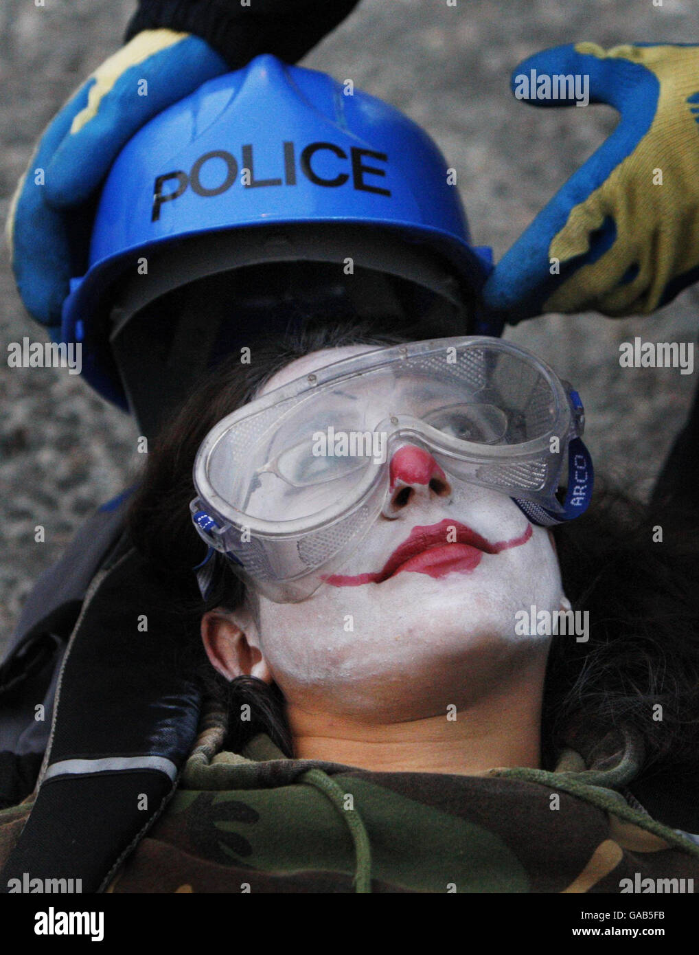 Am letzten Tag eines einjährigen Anti-Atomproteste vor Ort legte die Polizei einen Schutzhelm und eine Schutzbrille auf einen Protestanten, bevor sie sie freiSchnitt. Stockfoto