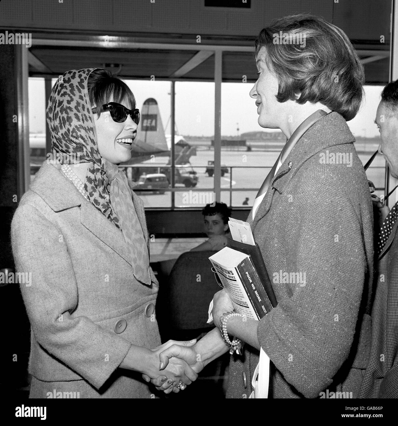 Die Schauspielerinnen Leslie Caron und Lois Maxwell treffen sich in der Lounge, um sich zu unterhalten, bevor sie nach Paris fliegen. Leslie geht zum Vergnügen - sie wird einkaufen; Lois ist geschäftlich unterwegs - sie wird am Flughafen Orly Außenaufnahmen für einen neuen Film, Champagne Flight, machen. Stockfoto