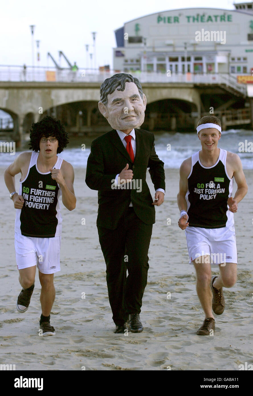 Oxfam-Aktivisten tragen Laufausrüstung und kleiden sich als Premierminister Gordon Brown am Bournemouth Beach, Dorset. Stockfoto