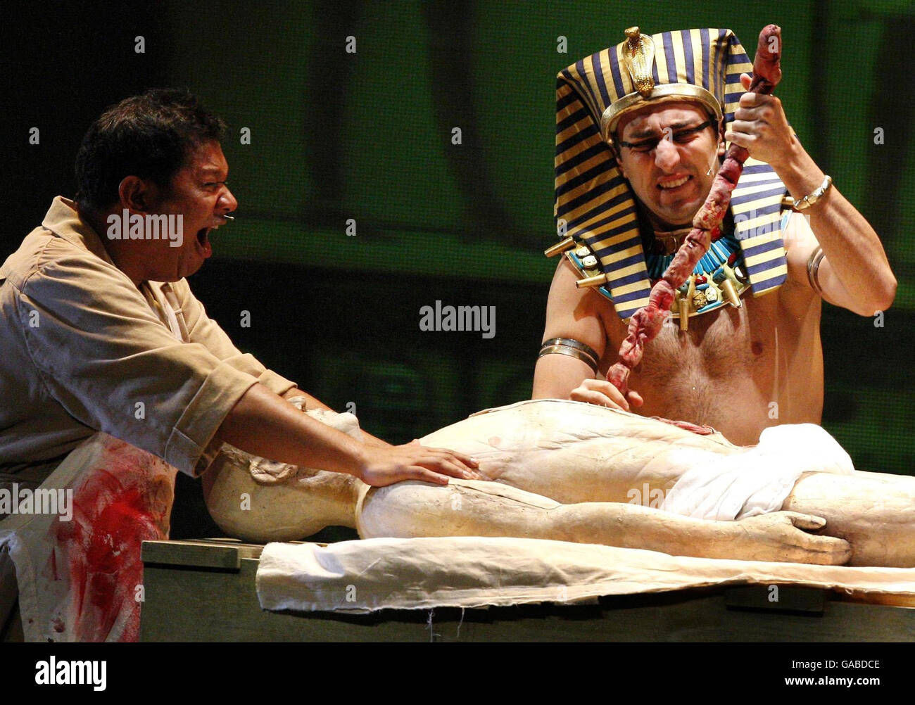 Darsteller von 'The Awful Egyptians' mumifizieren eine Leiche während der Horrible Histories Bühnenshow im Edinburgh Playhouse Theatre. Stockfoto
