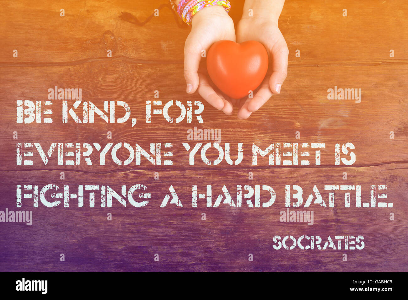 Freundlich sein, für alle, denen ihr begegnet, der griechische Philosoph Sokrates Zitat auf Bild der Hände mit Herz gedruckt- Stockfoto