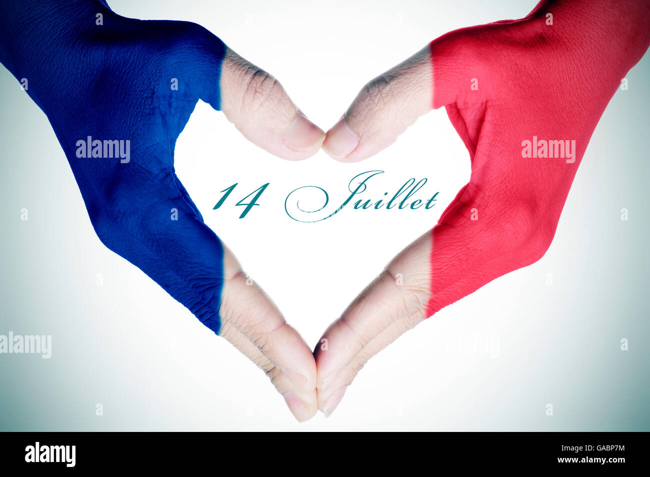Frau die Hände bilden ein Herz mit der Flagge von Frankreich und dem Text 14 Juillet, 14. Juli, der Tag von Frankreich gemustert, Stockfoto