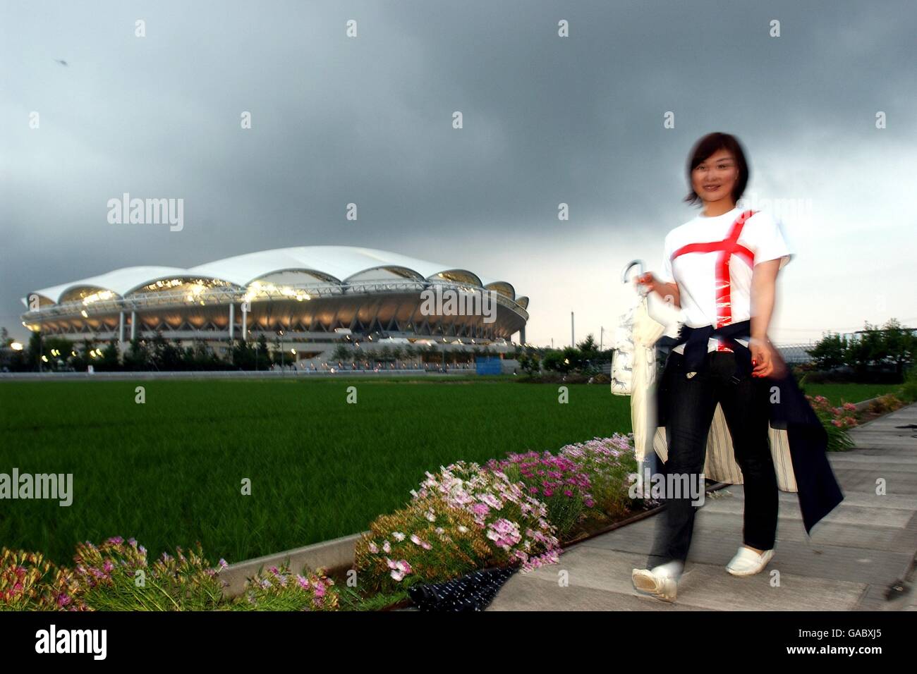 Fußball - FIFA Fußball-Weltmeisterschaft 2002 - zweite Runde - Dänemark gegen England. Ein japanischer England-Fan macht sich auf den Weg durch die Reisfelder zum Big Swan Stadium in Niigata, Japan, für das Spiel Dänemark gegen England Stockfoto