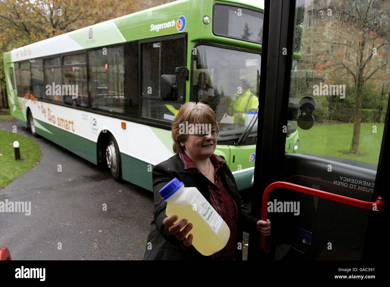 Eine nicht identifizierte Frau hält einen Container, der den Fahrgästen in Bussen übergeben wird, damit sie mit Speiseöl füllen können. Im Gegenzug erhalten sie ermäßigte Buspreise, da Stagecoach die ersten britischen Bio-Busse im Dean Castle Park in Kilmarnock startet. Stockfoto