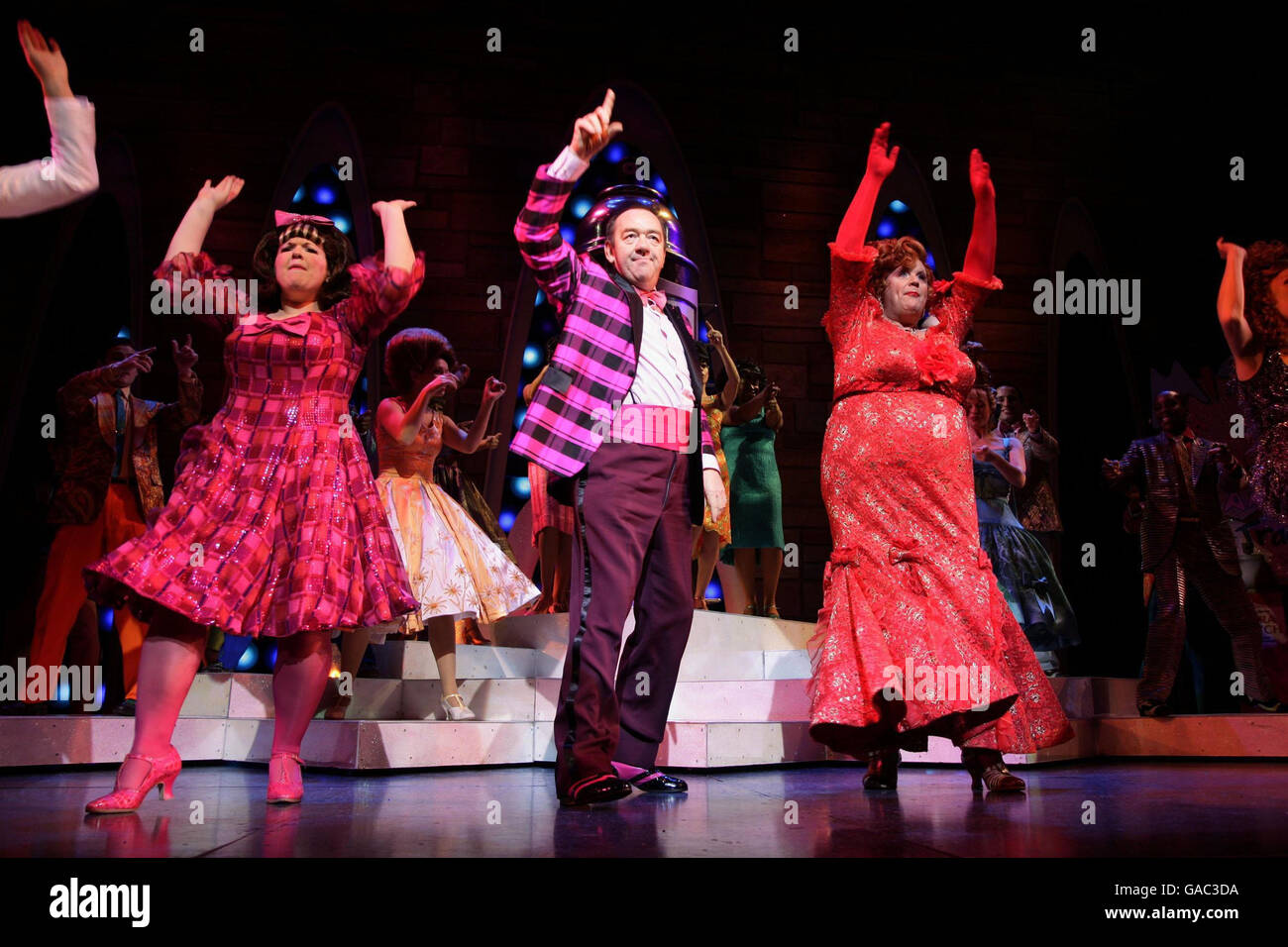 Die Besetzung des Musicals 'Hairspray', darunter (von links nach rechts) Leanne Jones (als Tracy Turnblad), Mel Smith (Wilbur Turnblad) und Michael Ball (Edna Turnblad) während einer Fotoanstellung im Shaftesbury Theatre im Zentrum von London. Stockfoto