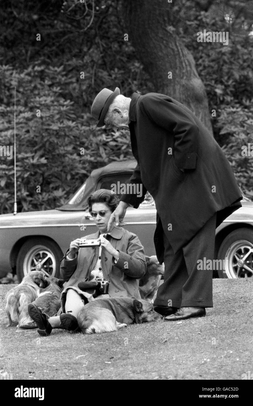 Die Königin sitzt auf einem grasbewachsenen Ufer mit den Corgis, mit Earl Mountbatten in Virginia Water, um Konkurrenten zu beobachten, darunter Prinz Philip beim Marathon der European Driving Championship, Teil der Royal Windsor Horse Show. Stockfoto