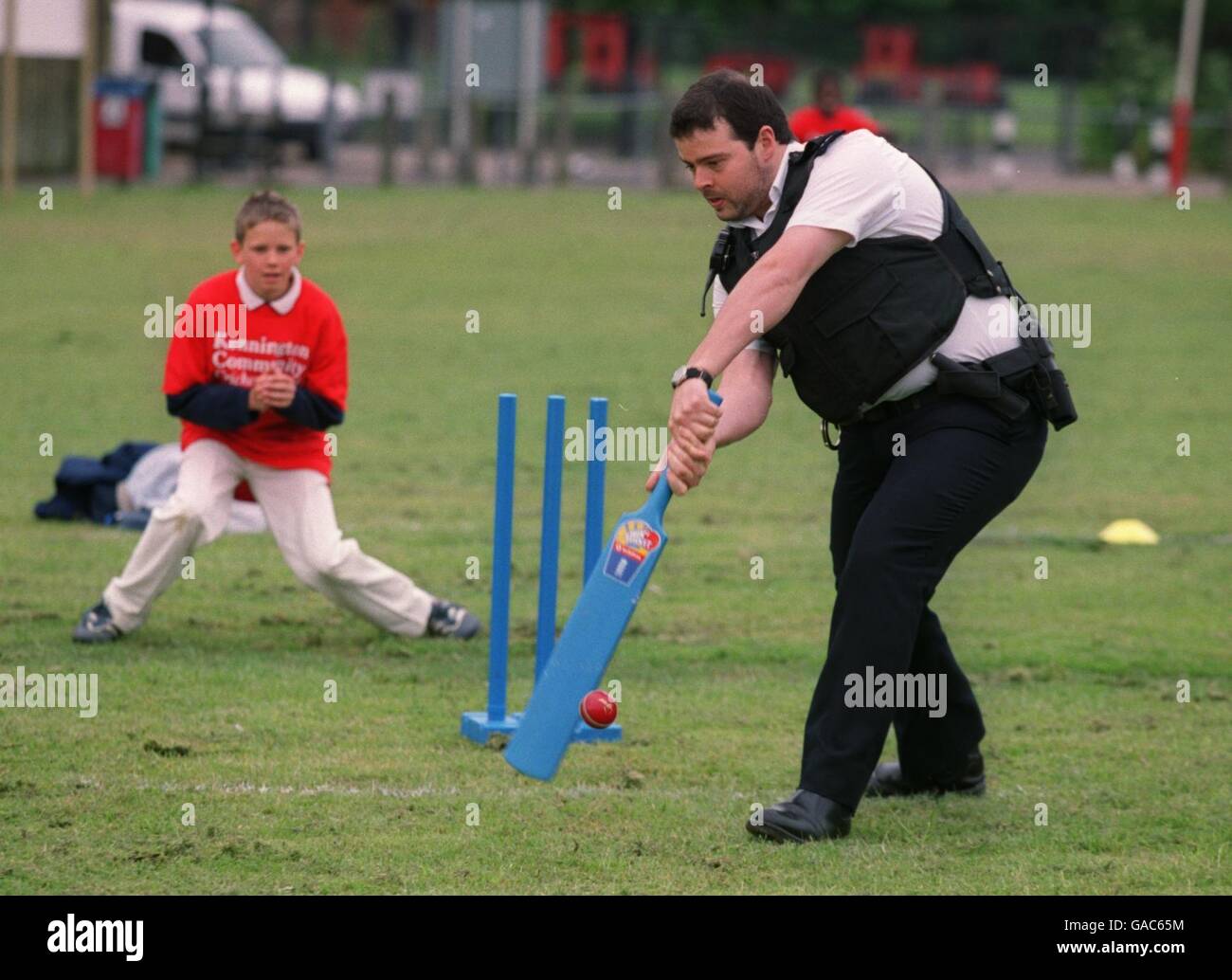 Cricket - Surrey - Channel Four Roadshow. Auf dem neuen Kennington Community Cricket Ground verwickelt sich ein Polizist mit den Kindern vor Ort Stockfoto