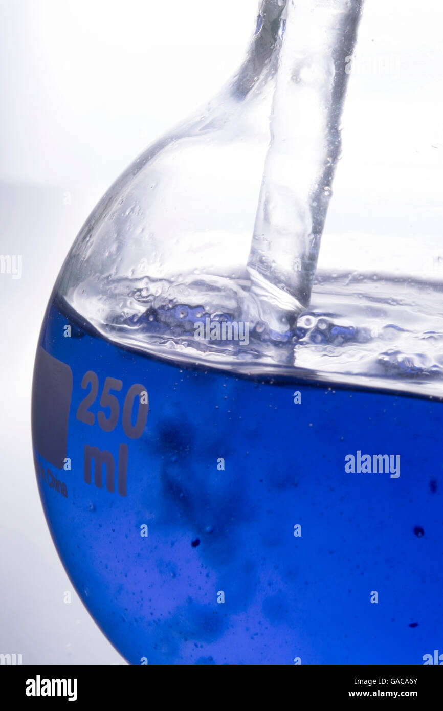 Blau Chemie ins kochende Flasche gießen Stockfoto