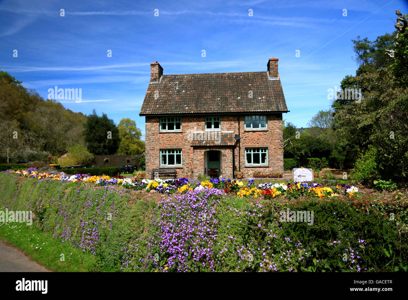 Ein quadratischer Häuschen mit einem Blumengarten gefüllt. Stockfoto