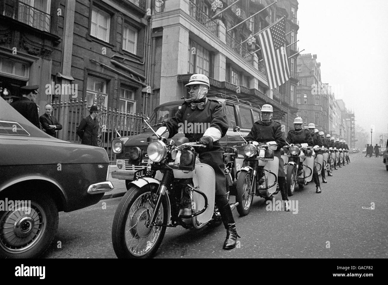 Schwere Polizei- und Sicherheitseskorte für Amerikas Präsidenten Richard Nixon, der vom Claridges Hotel zur Downing Street Nr. 10 in London fuhr, um mit Premierminister Harold Wilson zu sprechen. Die Polizei-Ausführer sind auf der Triumph Trophy TR6P, die den Modellnamen 'Saint' trug, der für 'Stops Anything in No Time' steht. Stockfoto