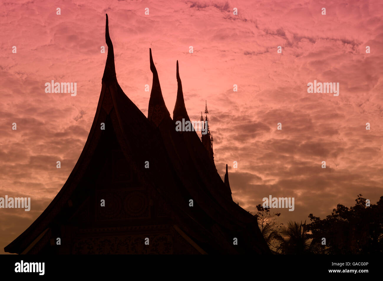 Wat Xieng Thong Silouetted gegen die untergehende Sonne, Luang Prabang, Laos Stockfoto