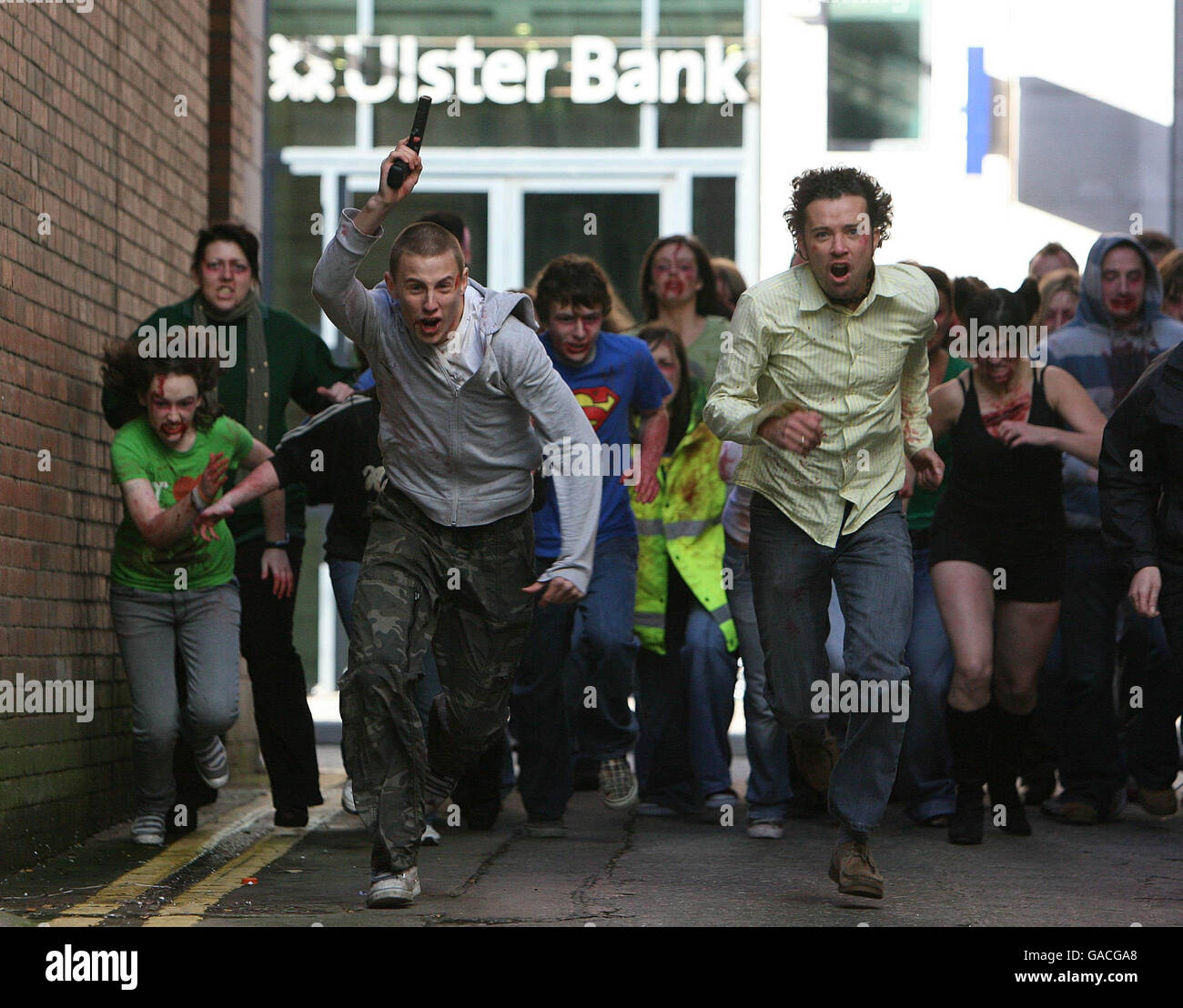 Die Schauspielerinnen Shane Todd und Allen Murrey Crawford werden von Zombies verfolgt, während die Dreharbeiten zu Battle of the Bone, dem ersten Horrorfilm der nordirischen Kampfkunst, beginnen. Stockfoto
