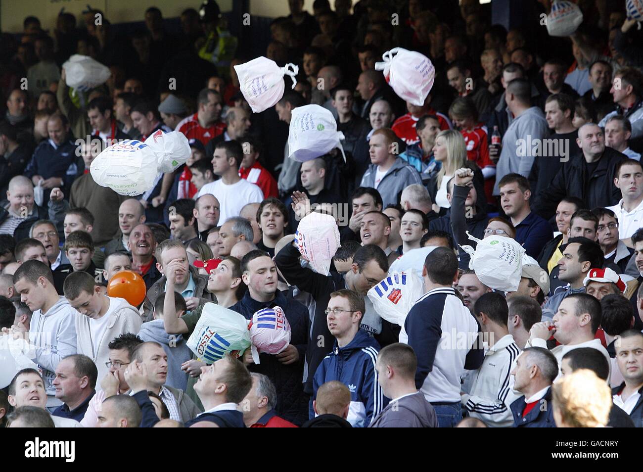 Liverpool-Fans werfen Tesco-Tragetaschen während des Spiels in die Luft, in die Tribüne. Die Supermarktkette Tesco plant den Bau eines neuen Stadions für den Everton Football Club im nahe gelegenen Kirkby. Stockfoto