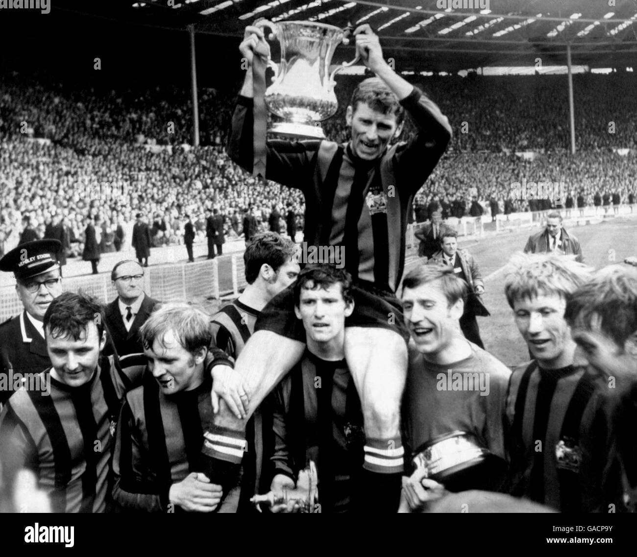 Manchester City Kapitän Tony Book hält den FA Cup hoch, während seine Teamkollegen um ihn herum feiern: (l-r) Glyn Pardoe, Francis Lee, Neil Young (halb versteckt), Mike Doyle, Torwart Harry Dowd, Colin Bell, Alan Oakes Stockfoto