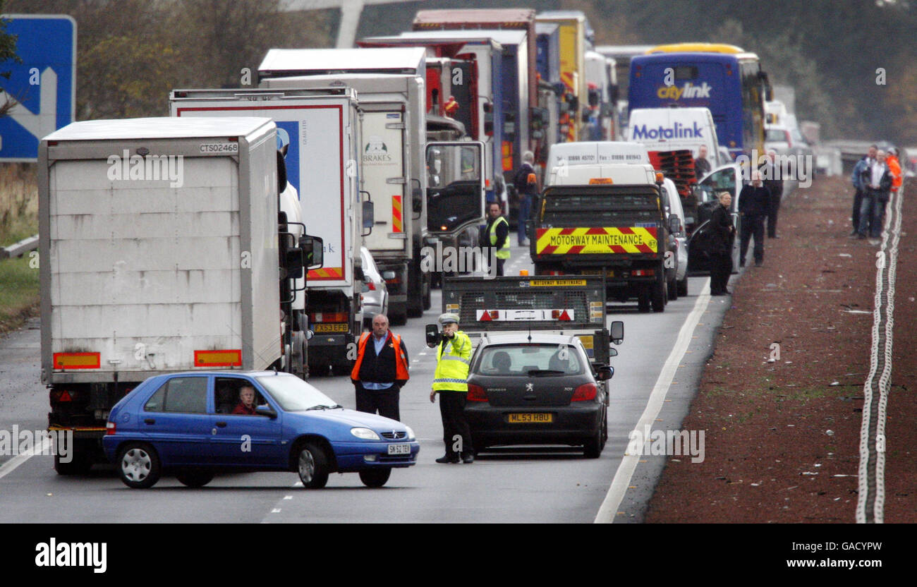 Ein Polizist weist Autofahrer an, die in einem Stau stecken bleiben, nach einem tödlichen Unfall in der Nähe von Livingston, Schottland, bei dem ein Mann starb, den falschen Weg auf dem M8-Motoway hinunter zu fahren. Stockfoto