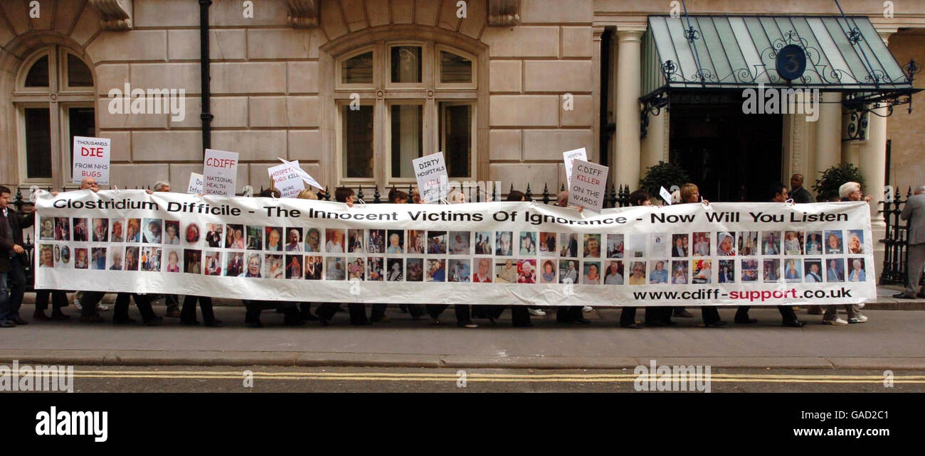 Angehörige von Patienten mit Clostridium difficile - einer bakteriellen Darminfektion - enthüllen ein Banner mit 80 Opfern der Krankheit, nach einem heutigen marsch nach Westminster. Stockfoto