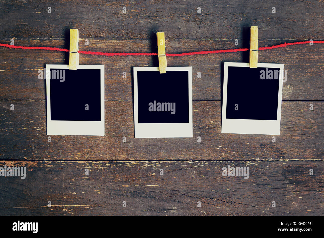 Drei leere Fotos Frame an der Wäscheleine hängen. Am alten Holz Hintergrund. Stockfoto