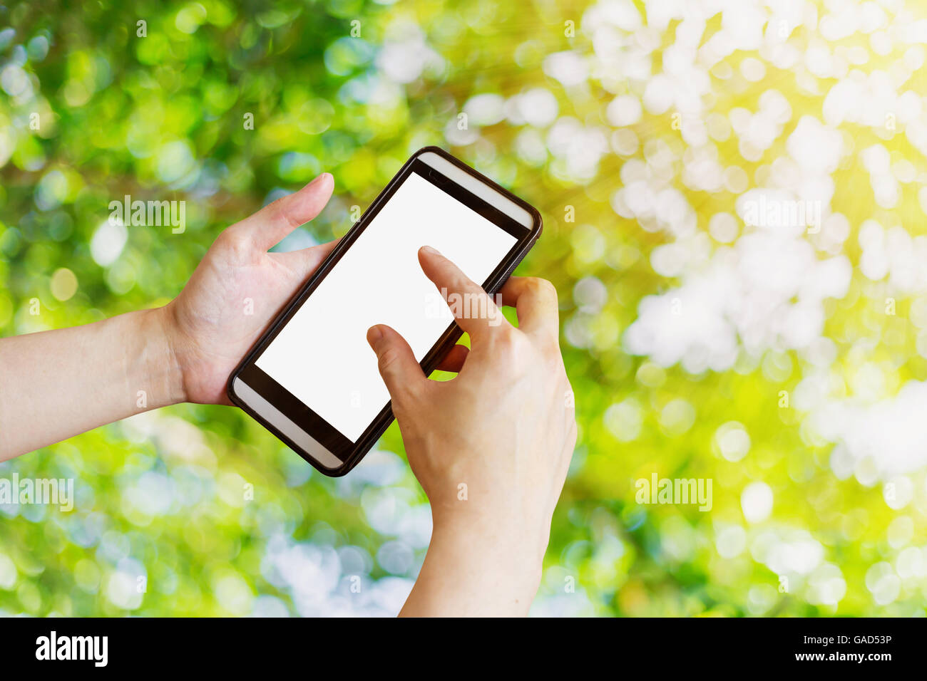 Hand-Frau mit Telefon im Garten mit Bokeh und Sonnenlicht. Stockfoto