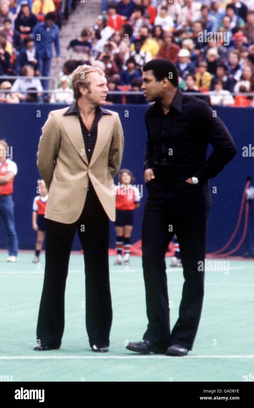 (L-R) der ehemalige England-Kapitän Bobby Moore chattet zum World Heavyweight Boxing Champion Muhammad Ali, während sie warten, Pele auf dem Platz für das letzte Match seiner Karriere zu begrüßen Stockfoto