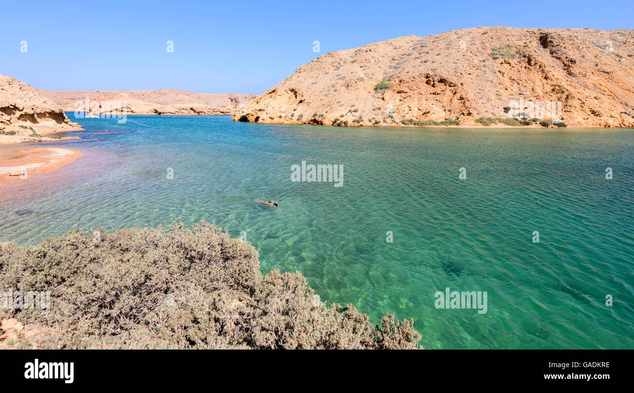 Frau Schwimmen allein im Ozean von einem Fjordähnlichen, Bandar Khayran, Sultante von Oman Stockfoto
