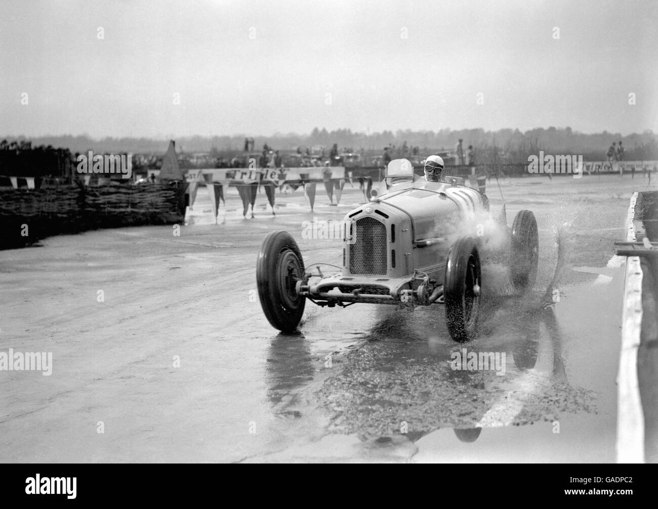 Kaye Don spritzt mit seinem Alfa Romeo während des Internationalen Trophy-Rennens durch eine Wasserpfütze. Stockfoto