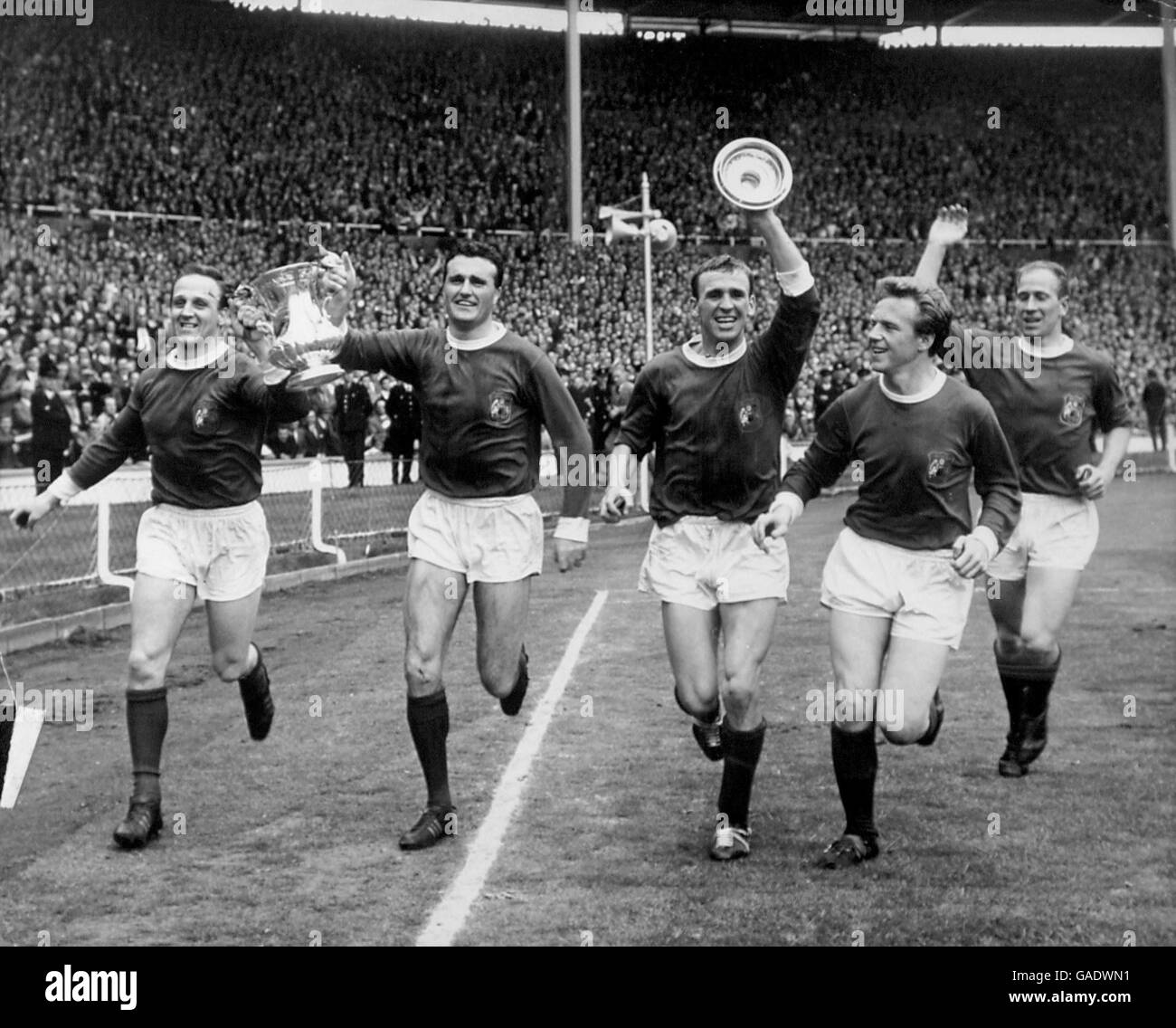 (L-R) Maurice Setters, Noel Cantwell, Pat Crerand, Albert Quixall und Bobby Charlton von Manchester United ziehen nach ihrem Sieg über Leicester City im Jahr 3-1 den FA Cup um Wembley herum Stockfoto