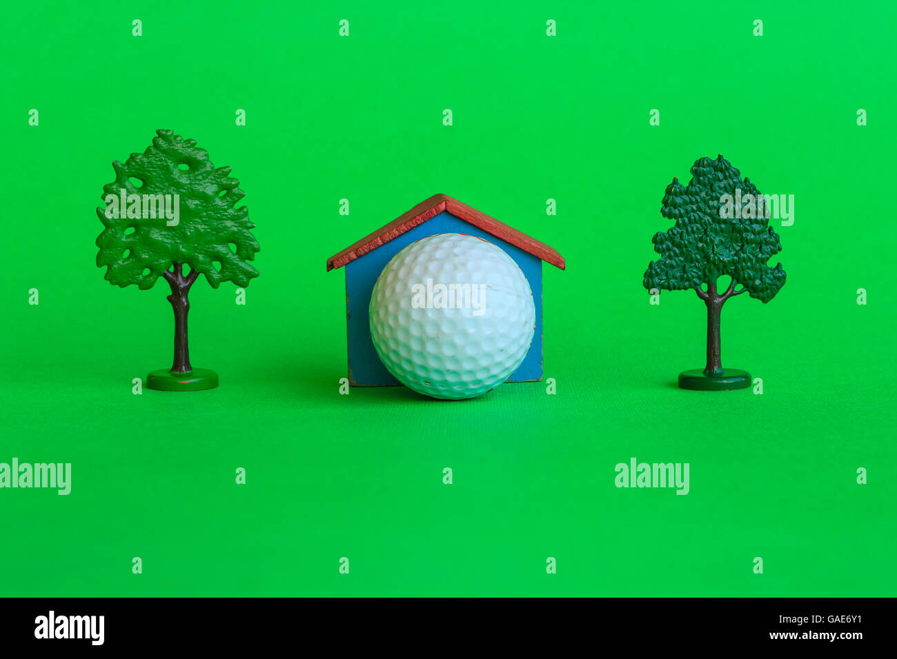 ein Haus mit einem Golfball, umgeben von Bäumen und viel Grün, ist das Symbol für das Vorhandensein eines Golf-Club Stockfoto