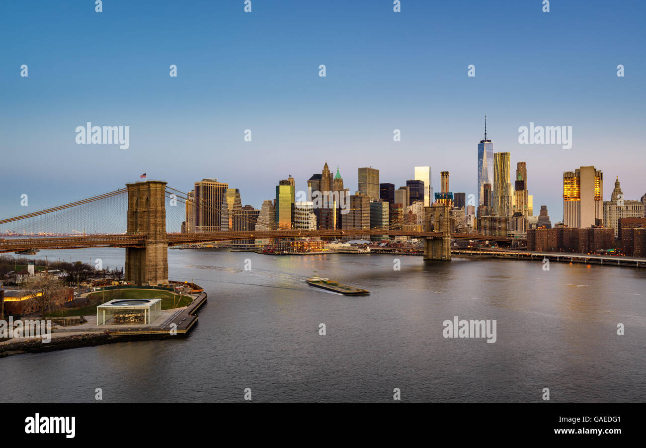 Blick auf die Brooklyn Bridge bei Sonnenaufgang mit Manhattan Financial District Wolkenkratzern und dem East River. New York City Stockfoto