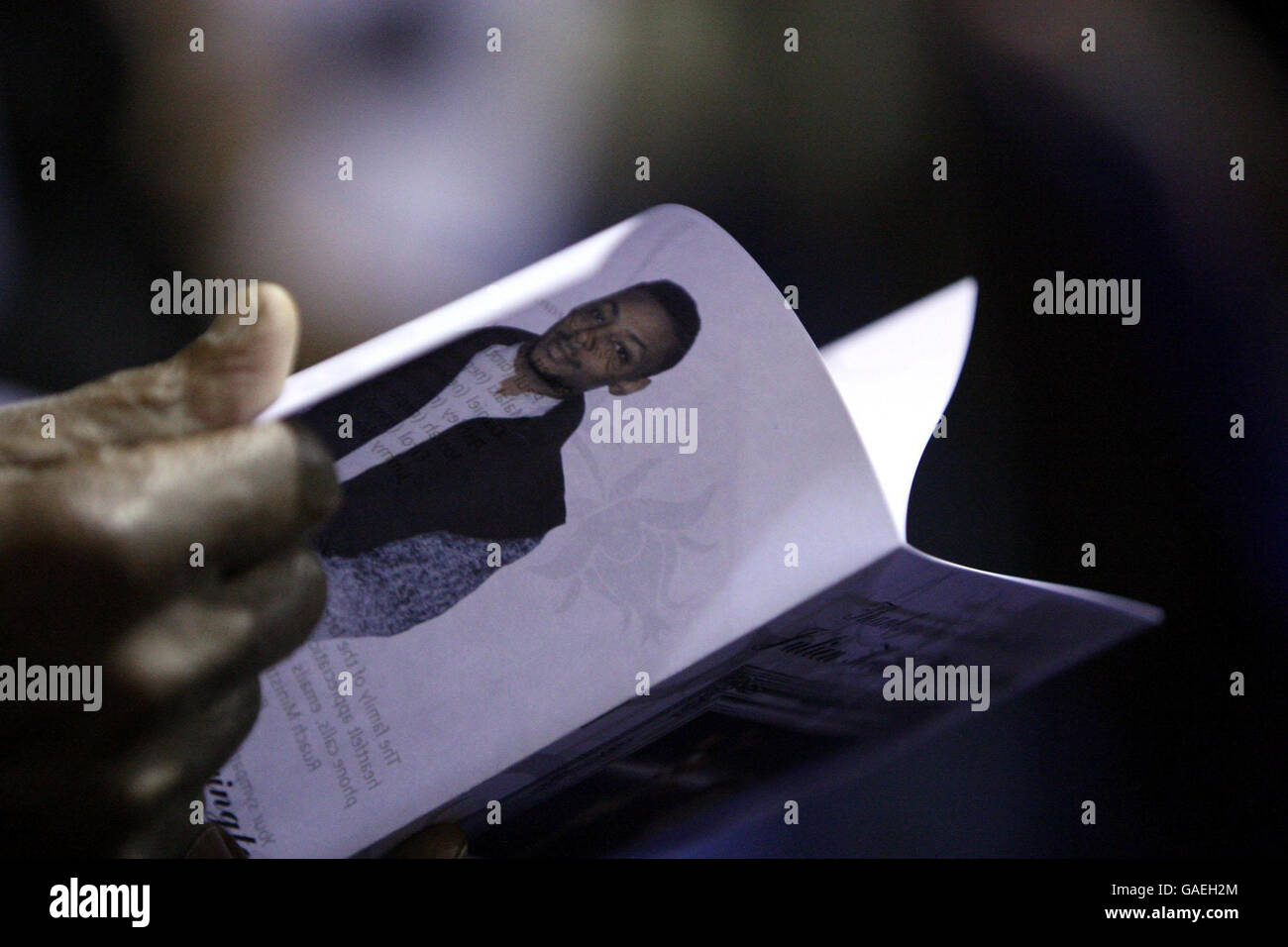Ein Trauermann liest aus der Dienstordnung bei der Beerdigung von Julien Warrington, in den Ruach Ministries in Brixton, South London. Stockfoto