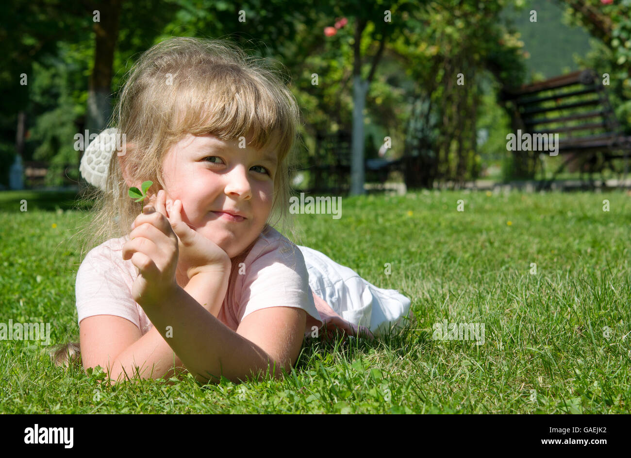 fröhliches Mädchen ins frische Gras liegend Stockfoto
