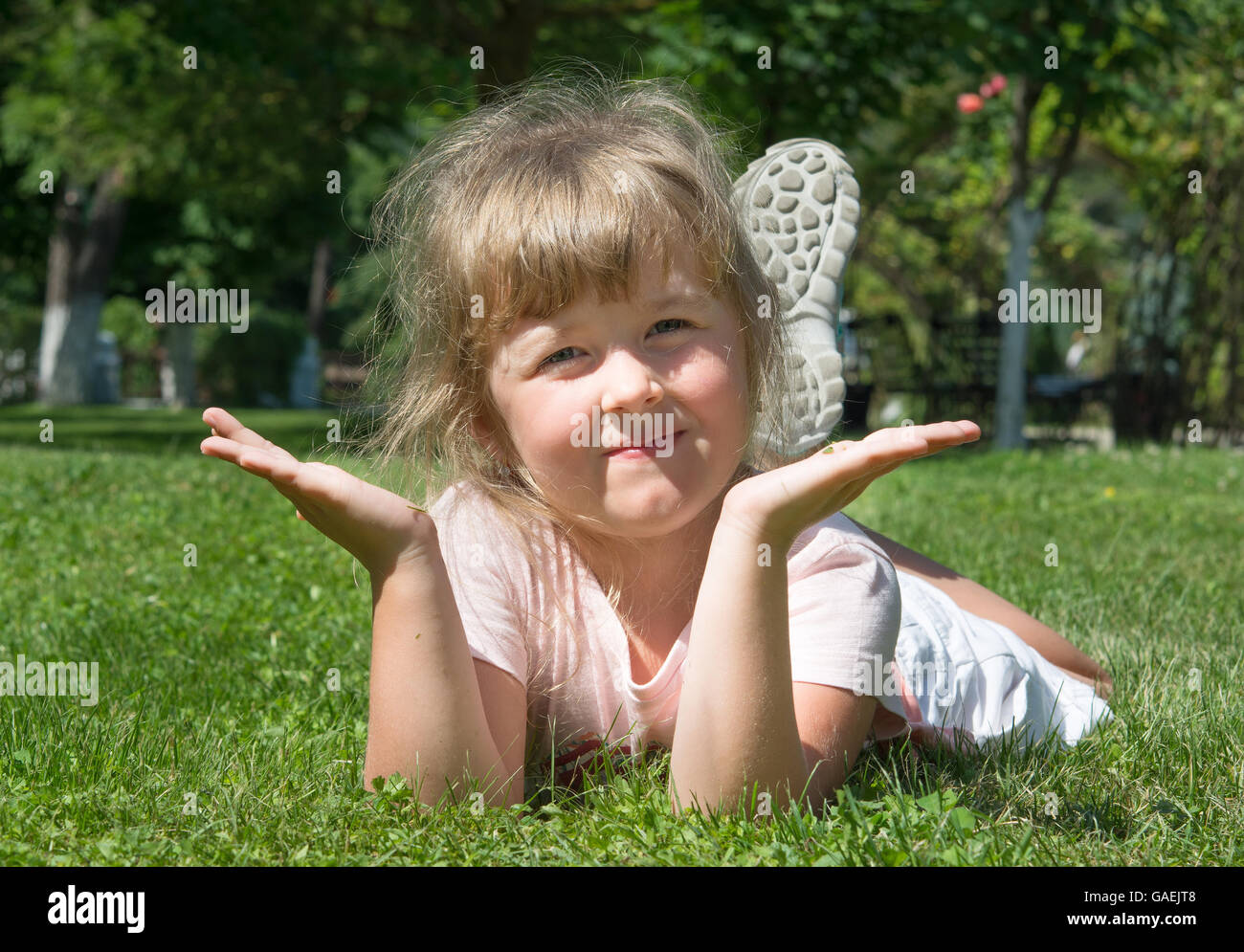 fröhliche kleine Mädchen auf der Wiese liegend Stockfoto