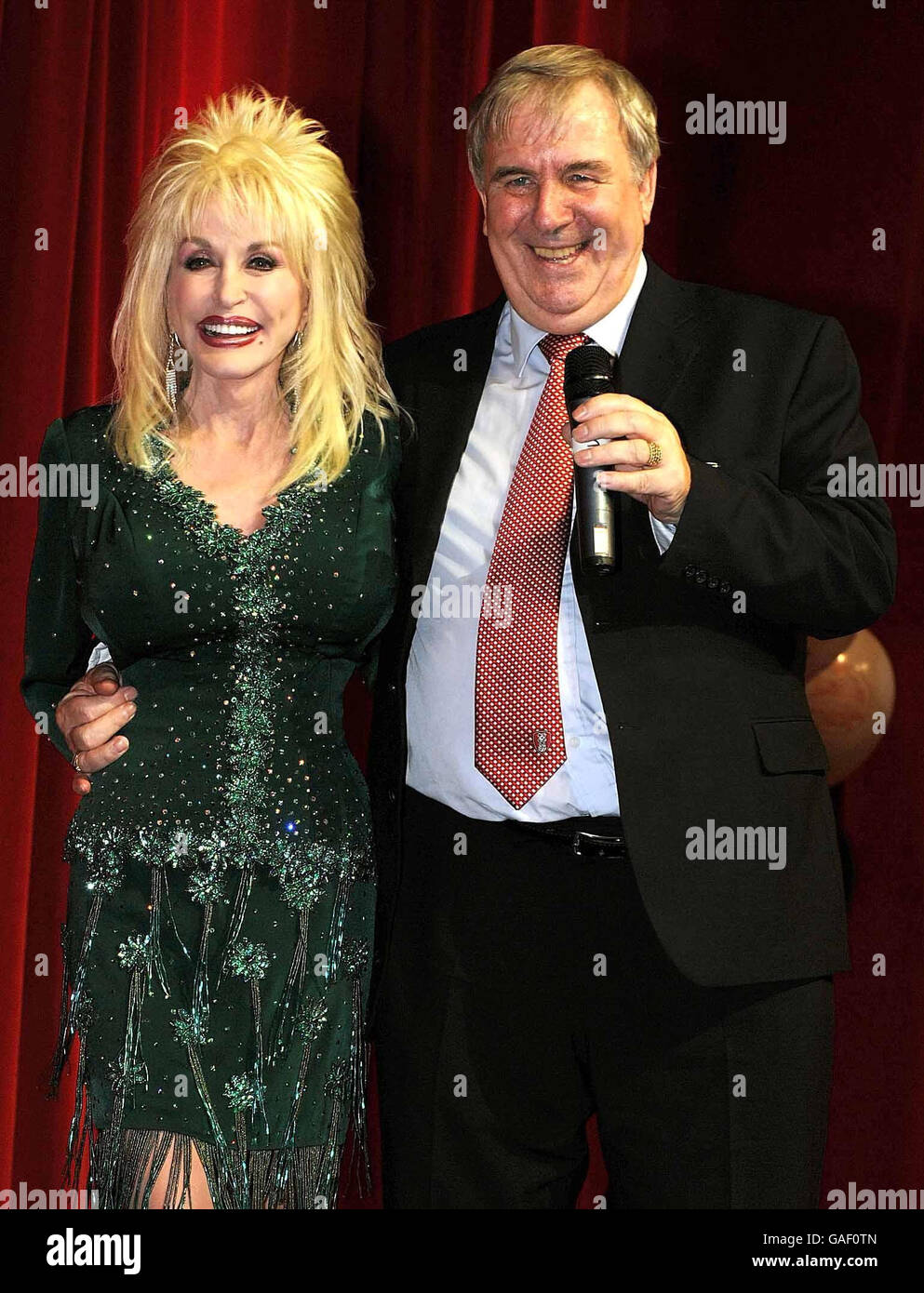 Country-Superstar Dolly Parton mit Ratsmitglied Roger Parker, dem Leiter von RMBC, bei der Einführung der Imagination Library, ihres Kinderalphabetenprogramms im Magna Science Adventure Center in Rotherham, South Yorkshire. Stockfoto